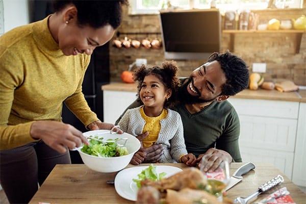 Family eating dinner in a well lit kitchen